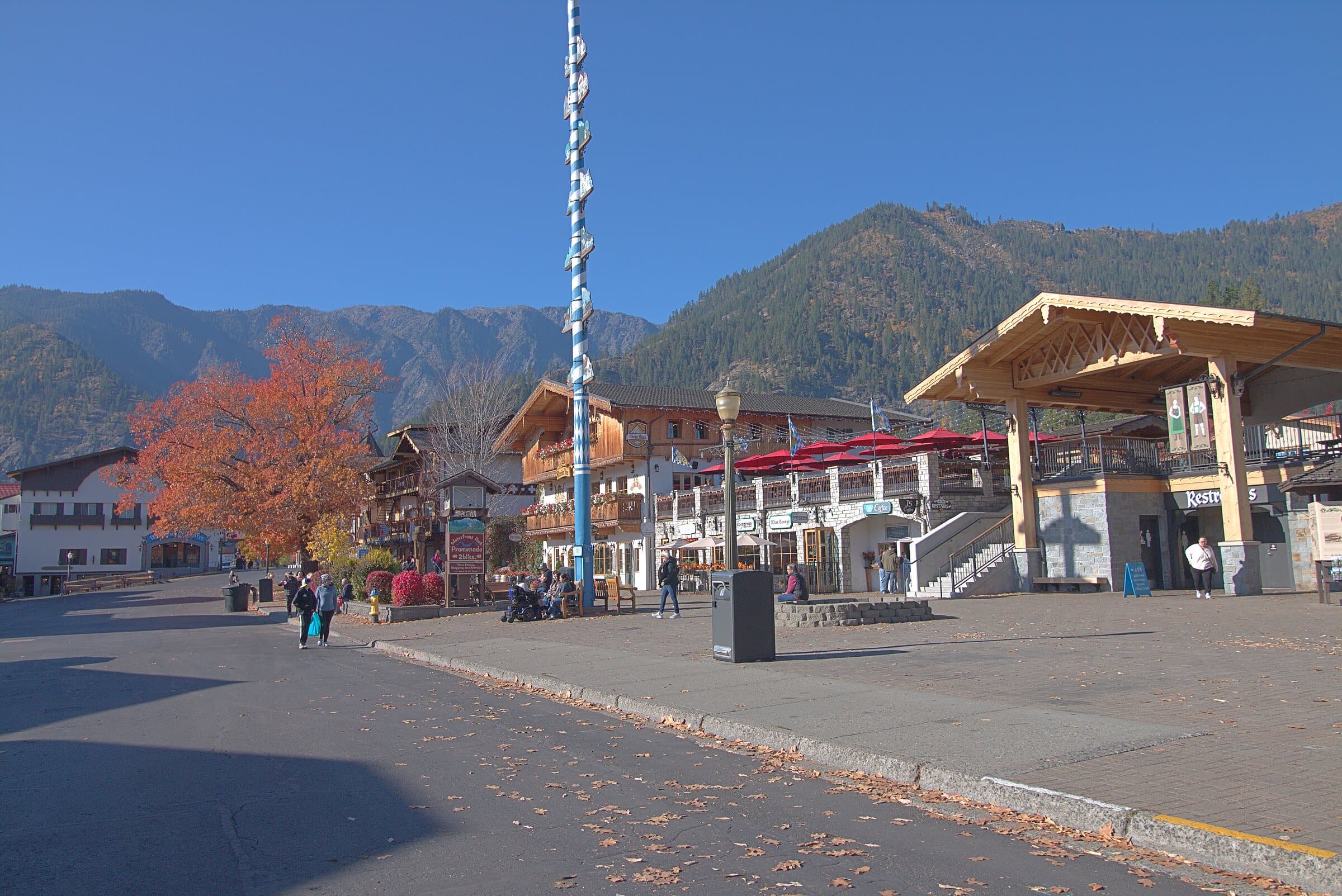 Front Street in Leavenworth in fall, with the maypole, a red maple and the mountains behind